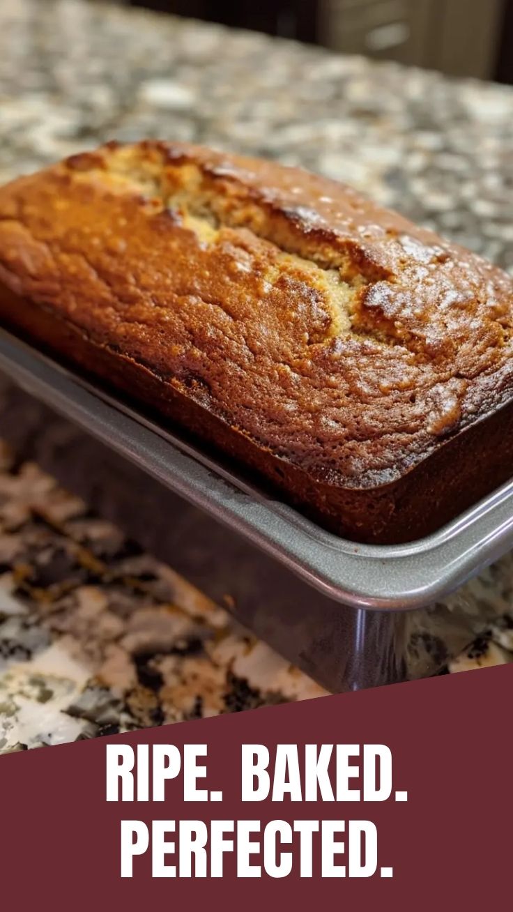 A freshly baked loaf of banana bread on a cutting board.
