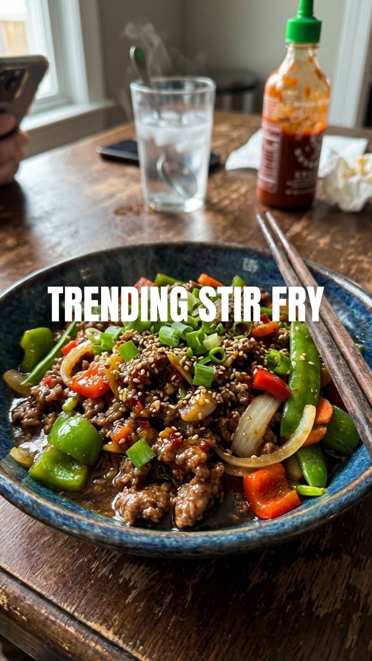 A vibrant ground beef stir fry dish in a serving bowl, garnished with fresh herbs.