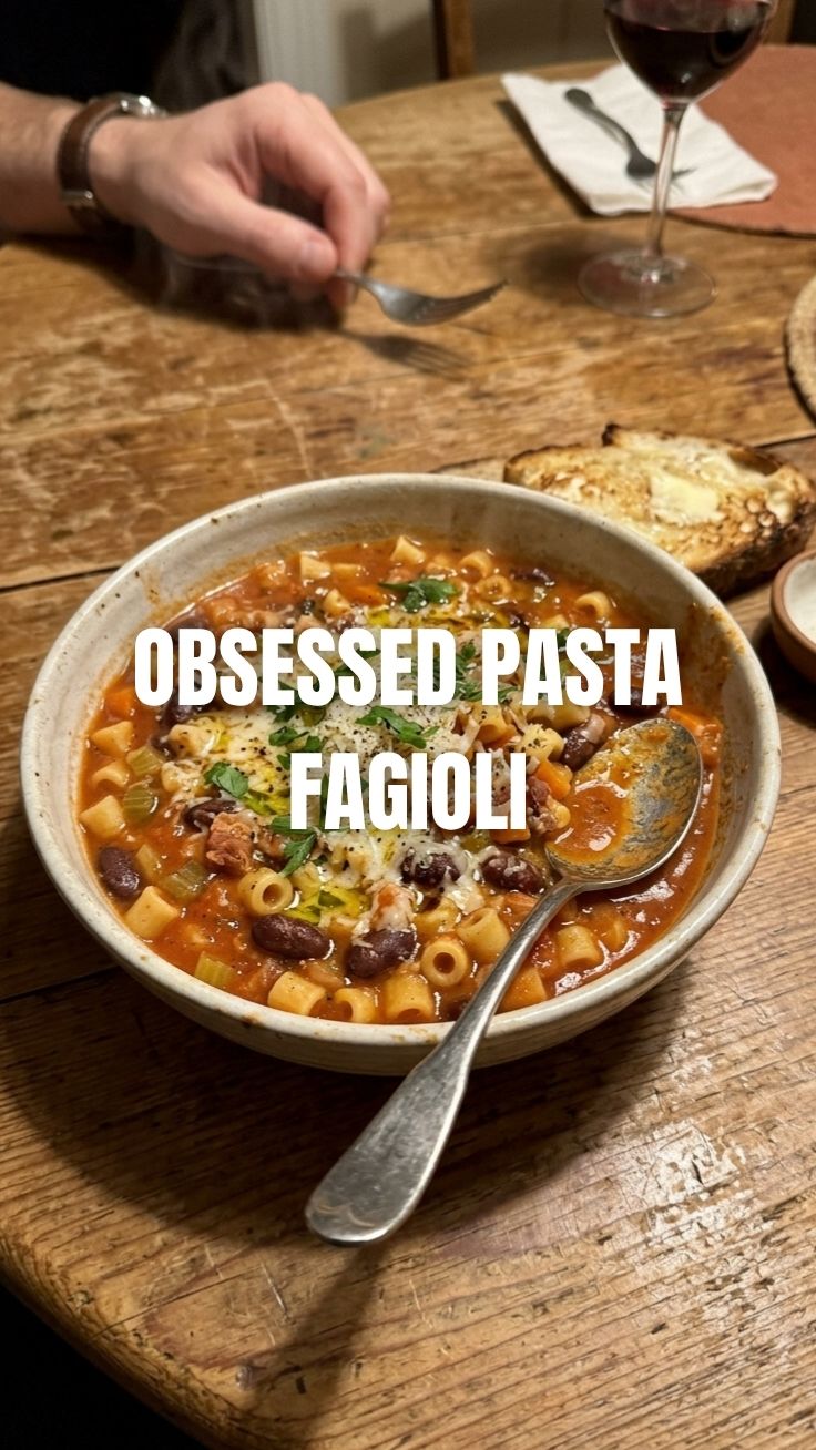 A steaming bowl of hearty pasta fagioli filled with pasta, beans, and vegetables.