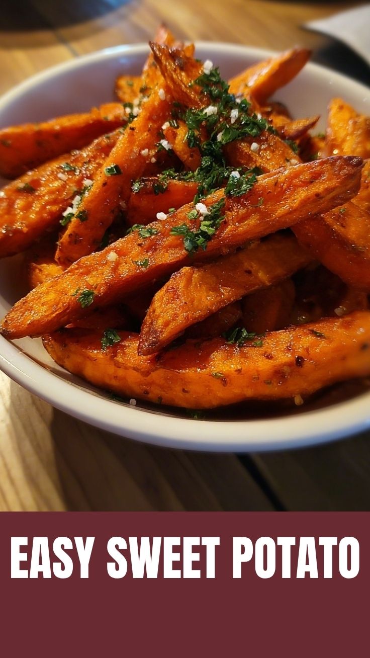 A close-up of crispy, seasoned sweet potato fries piled high