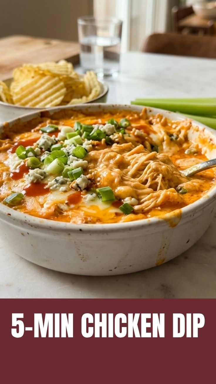 A hot dish of creamy Buffalo chicken dip, garnished with chopped green onions.