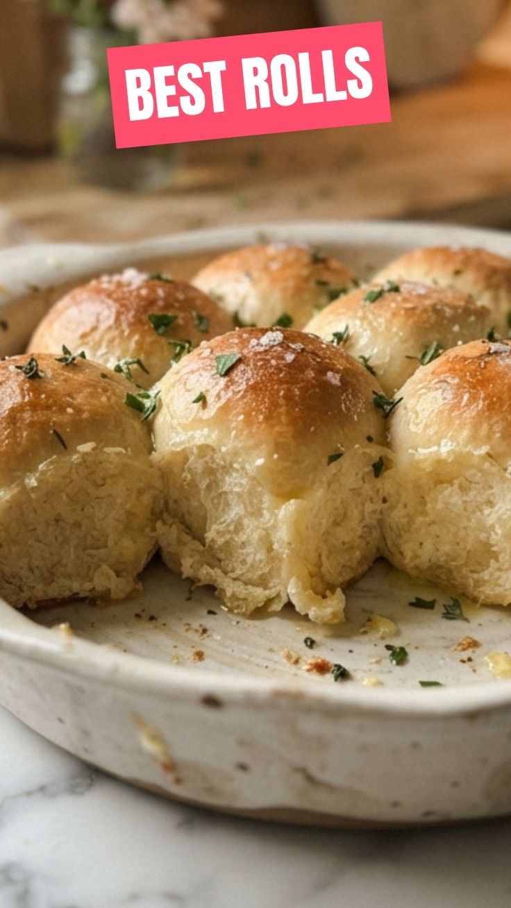 A basket of freshly baked golden brown dinner rolls.