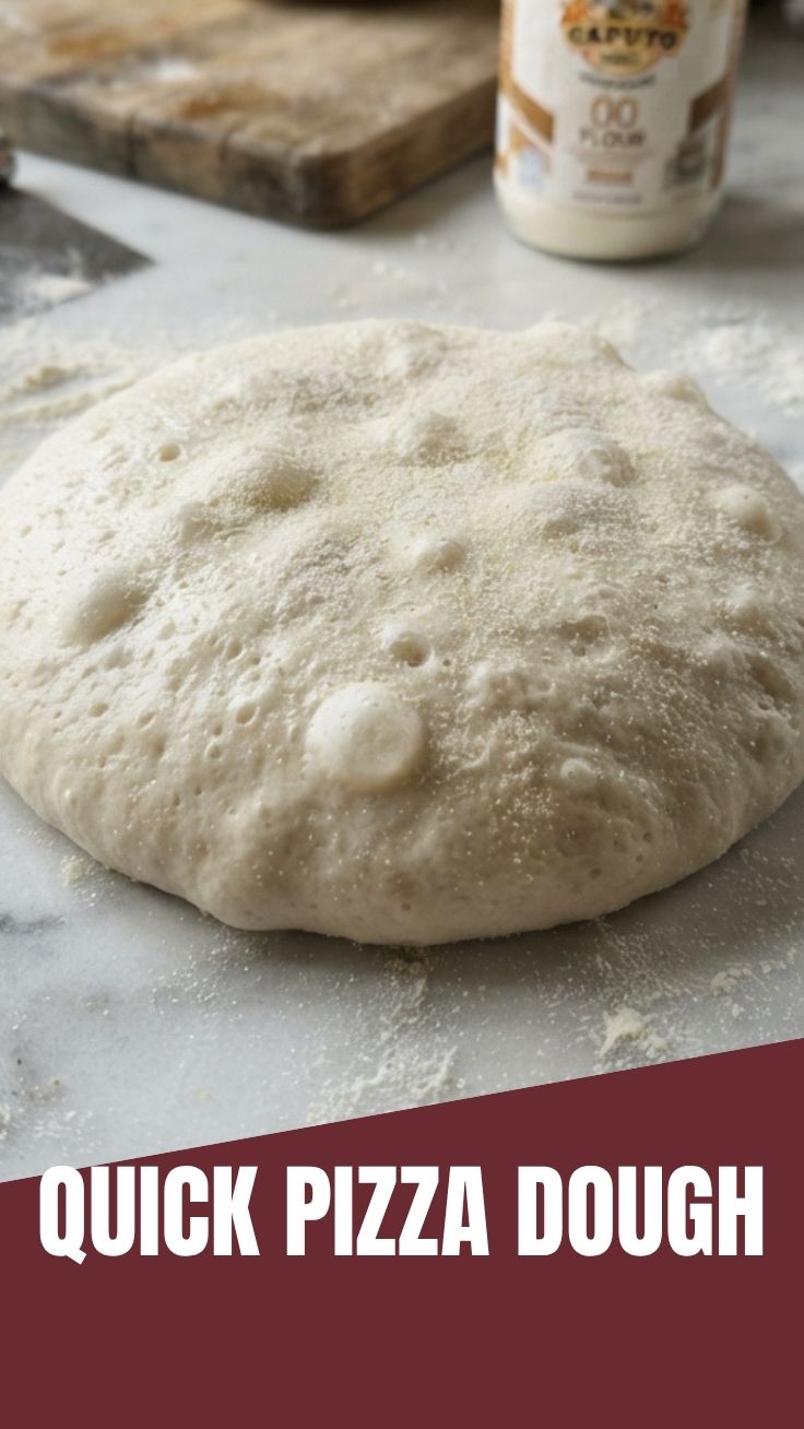 Freshly made pizza dough resting on a floured surface, ready for shaping